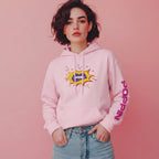 Person wearing a pink hoodie with a graphic design on a pink background